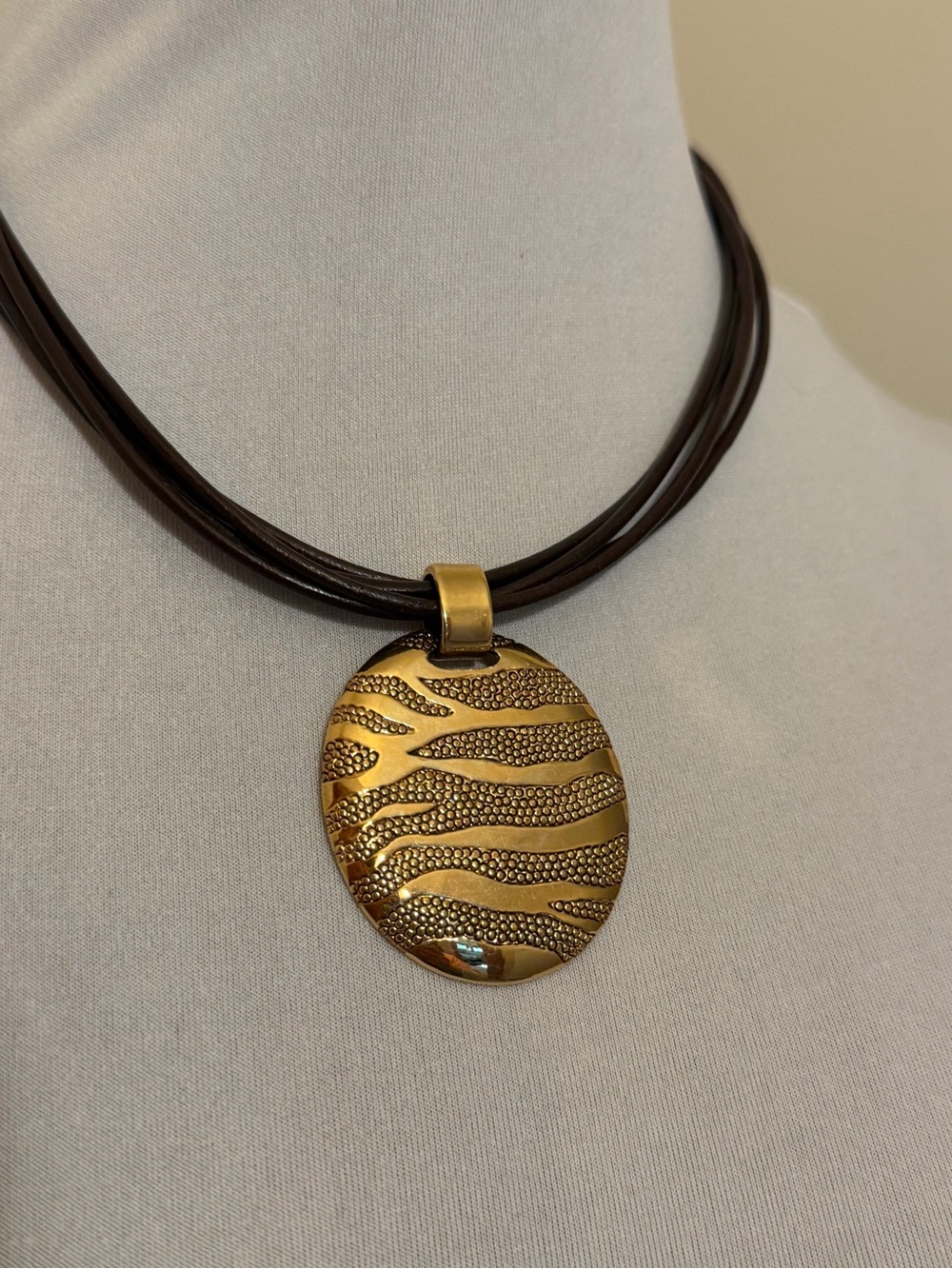 Gold Textured Oval Pendant Necklace with Brown Pleather Multi String Chain.